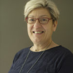 Headshot of Maria Huffman in a navy blue sweater.