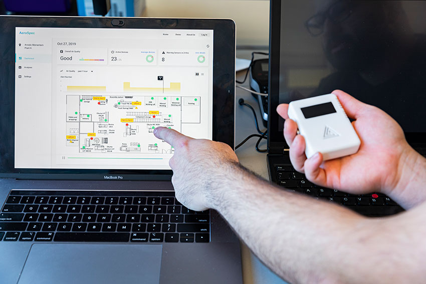 Student holds small device and point to analysis on the computer