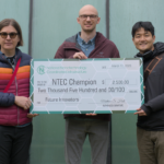 Three people holding an oversized novelty check.