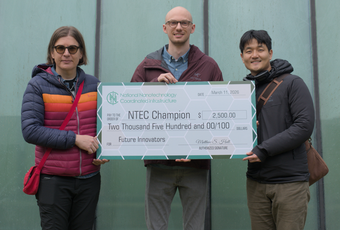 Three people holding an oversized novelty check.